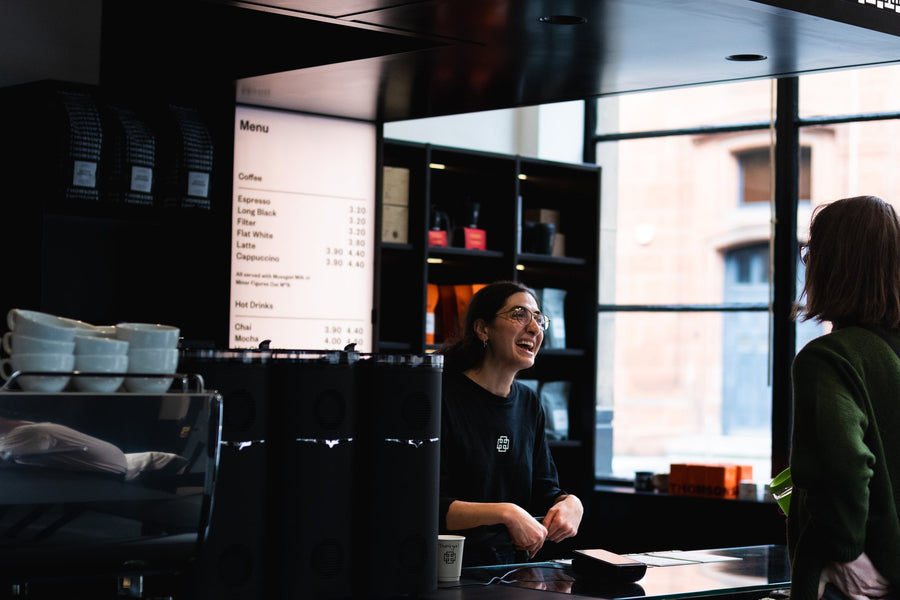 A Thomson's barista with a customer at the Candleriggs counter