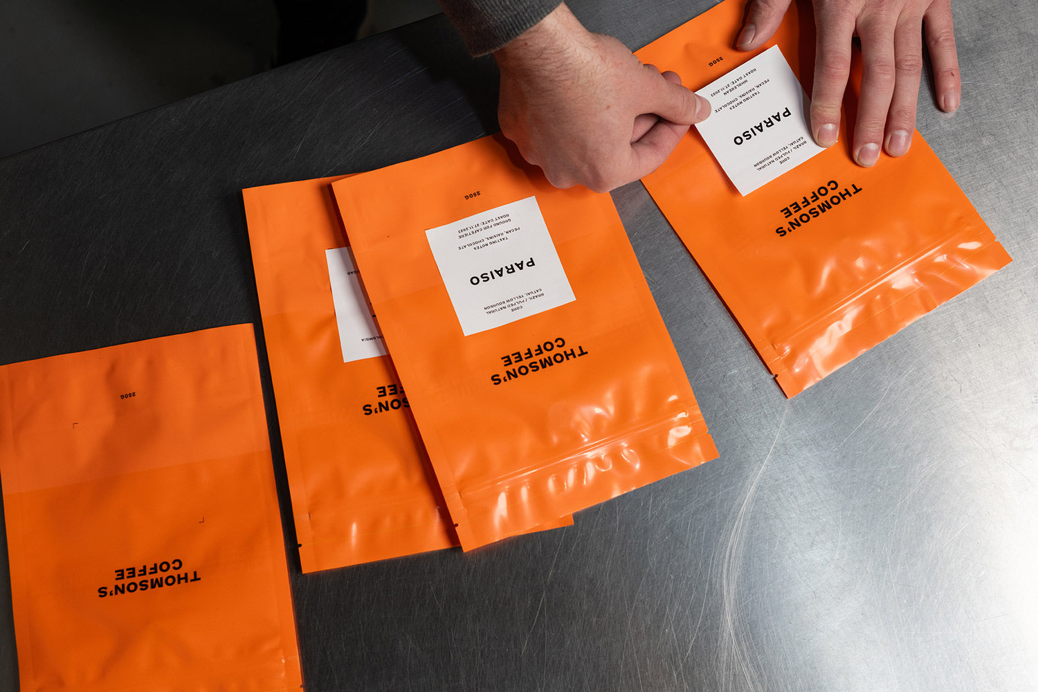 Orange coffee bags being labeled 
